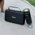 The Gustosa hard-shell carrying case and MyGustosa portable espresso maker placed side by side on a white knit blanket outdoors, showcasing the complete and compact travel coffee setup.