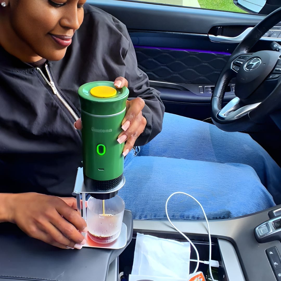 A smiling woman sitting in the passenger seat of a car, using MyGustosa portable espresso maker mounted on the Gustosa Bracket to brew a fresh espresso, demonstrating how easy it is to enjoy real coffee on the road.
