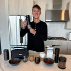 Smiling man with Gustosa portable coffee maker, travel bag, grinder, thermos, and fresh coffee setup